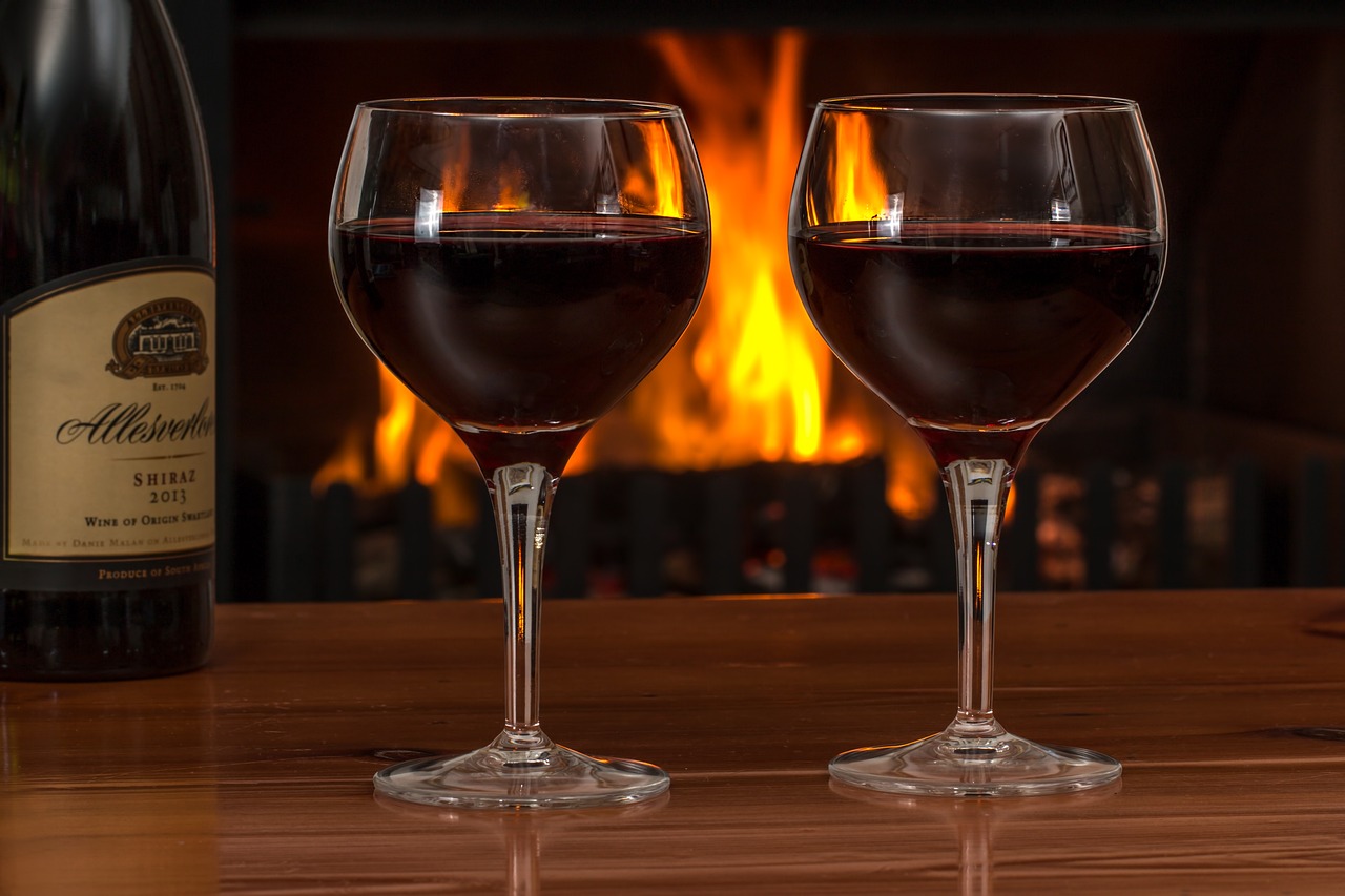 red wine, glasses, log fire